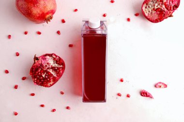 Beyaz arka planda bir şişede nar suyu. Boşluğu kopyala