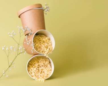 Delivery concept. Noodles in glasses on a green background. Copy space clipart