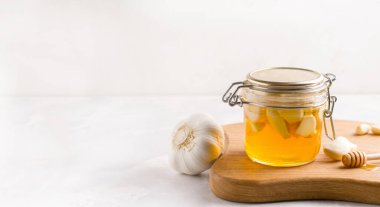 Hafif arka planda sarımsaklı mayalanmış bal. Uzayı kopyala Pankart