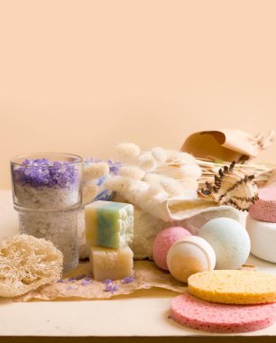 Bej rengi doğal arka planda banyo yapmak için bir takım ürünler.