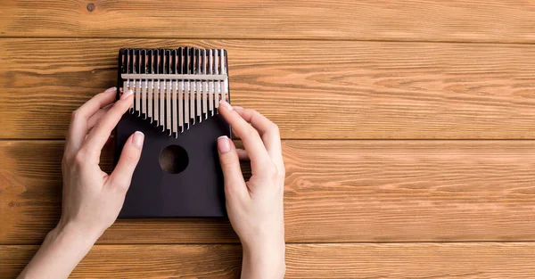 Ahşap bir arka planda Kalimba müzik aleti. Uzayı kopyala Pankart