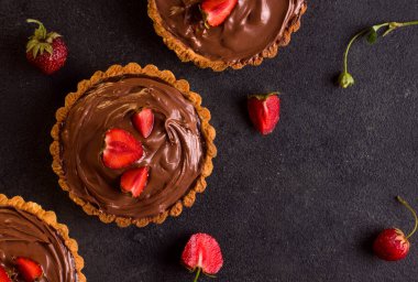 Siyah arka planda çilekli tart çikolatası. Yukarıdan bak. Boşluğu kopyala