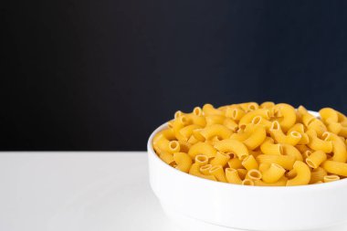 Çiğ, çiğ, çiğ makarna, beyaz arka planda makarna. Fesleğen domates pesto sosu. Ev yapımı taze İtalyan yemeği. Sağlıklı bir yemek için tam teşekküllü vejetaryen makarna.