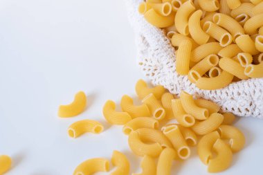 Çiğ, çiğ, çiğ makarna, beyaz arka planda makarna. Fesleğen domates pesto sosu. Ev yapımı taze İtalyan yemeği. Sağlıklı bir yemek için tam teşekküllü vejetaryen makarna.