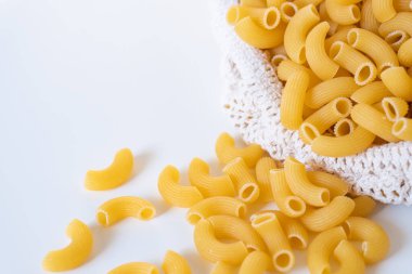 Çiğ, çiğ, çiğ makarna, beyaz arka planda makarna. Fesleğen domates pesto sosu. Ev yapımı taze İtalyan yemeği. Sağlıklı bir yemek için tam teşekküllü vejetaryen makarna.