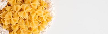 Çiğ pişmemiş Farfalle makarna makarna makarna beyaz kâse ahşap arka plan fesleğen domates pesto sosu ev yapımı İtalyan yemeği organik buğday vegan spagetti sağlıklı bir yemek için