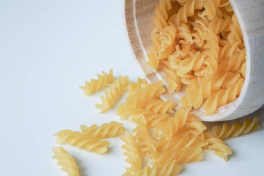 Çiğ pişmemiş Fusilli makarna makarna makarna beyaz arka planda fesleğen domates pesto sosu ev yapımı taze İtalyan yemeği organik, vejetaryen makarna sağlıklı bir yemek için.