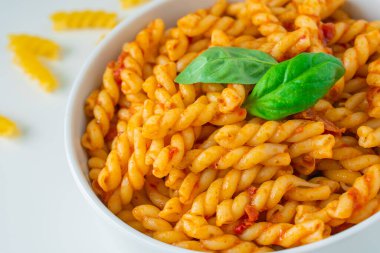 Gemelli geleneksel makarna ile ev yapımı İtalyan yemeği bolognese kırmızı rosso pesto sosu sağlıklı organik domates baharatlı acı biberli vegan pişirme tarifi.