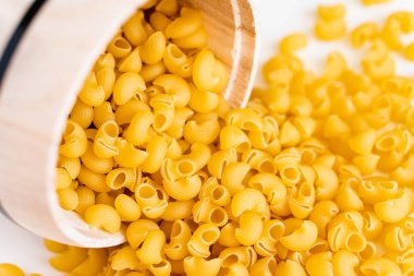 Çiğ, çiğ, çiğ, pipo makarna makarna makarna beyaz kâse ahşap arka plan fesleğen domates pesto sosu ev yapımı İtalyan yemeği tam buğday vejetaryen spagettisi sağlıklı bir yemek için