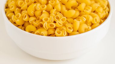 Çiğ, çiğ, çiğ, pipo makarna makarna makarna beyaz kâse ahşap arka plan fesleğen domates pesto sosu ev yapımı İtalyan yemeği tam buğday vejetaryen spagettisi sağlıklı bir yemek için