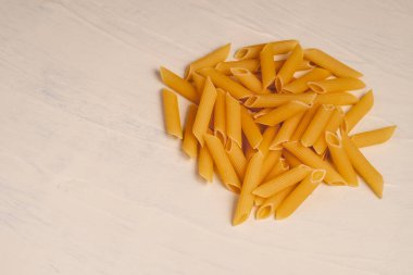 Beyaz arka planda bir kasede çiğ pişmemiş makarna. Fesleğen domates pesto sosu için iyi. Ev yapımı İtalyan yemeği. Biyolojik, organik, vejetaryen, sağlıklı bir yemek için spagetti.