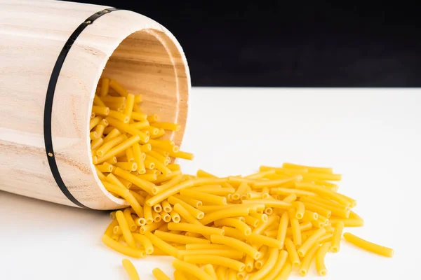 生乾燥調理されたマカロニパスタスパゲティ白いボウルに麺バジルトマトペストソースのための木製の背景自家製イタリア料理健康的な食事のための有機小麦ビーガンスパゲティ — ストック写真