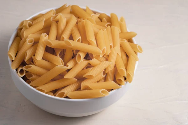 Pasta Penne Cruda Seca Sin Cocer Tazón Sobre Fondo Blanco — Foto de Stock