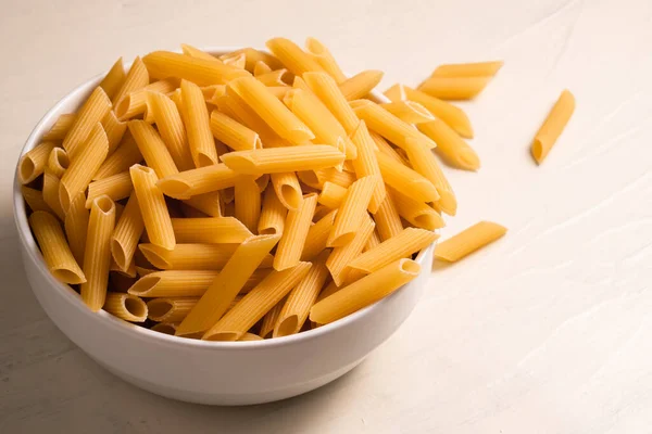 Pasta Penne Cruda Seca Sin Cocer Tazón Sobre Fondo Blanco — Foto de Stock