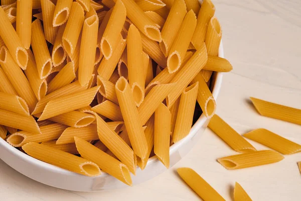 Rauwe Droge Ongekookte Penne Pasta Een Kom Witte Achtergrond Goed — Stockfoto