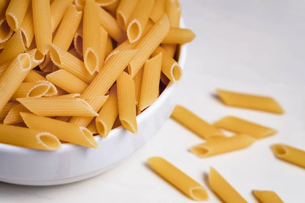 Pasta Penne Cruda Seca Sin Cocer Tazón Sobre Fondo Blanco — Foto de Stock