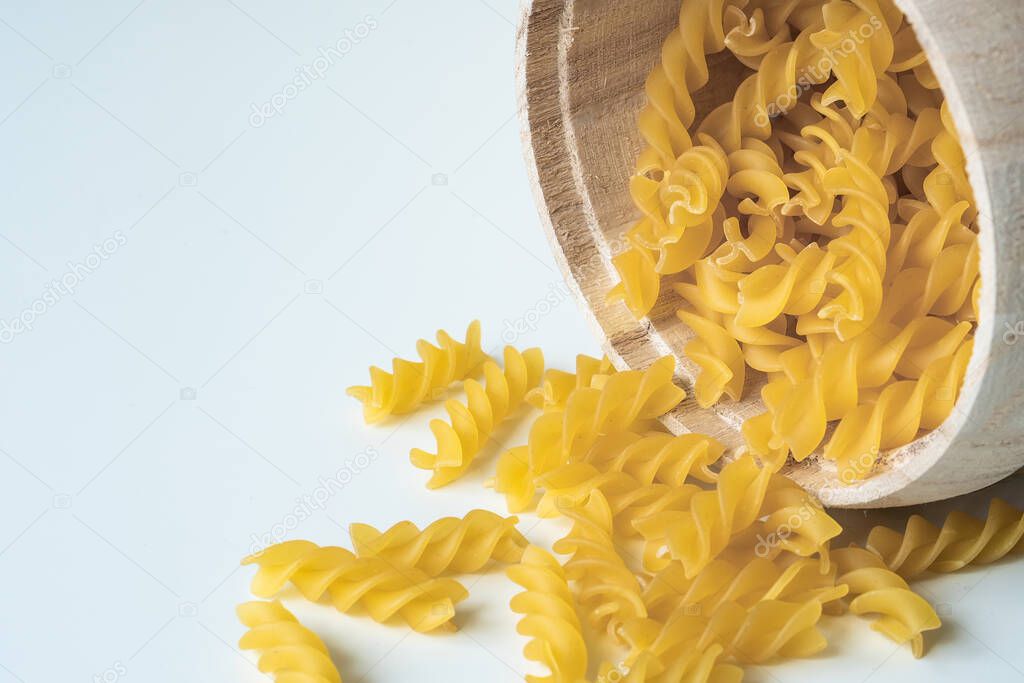 Raw dry uncooked Fusilli pasta spaghetti noodle on white background Good for basil tomato pesto sauce Homemade fresh Italian food organic whole wheat vegan spaghetti noodle for a healthy meal