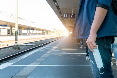 Boş platform tren durağı metrosu metro istasyonu yolcuları turistler ayakta bekliyor yeni normal sosyal mesafeli hijyen maskeli güvenli yolculuk covid corona virüsünden korunmak için