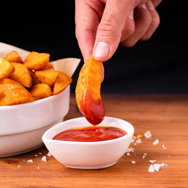 Tradition french fries from organic bio potato wedges with skin dip in ketchup