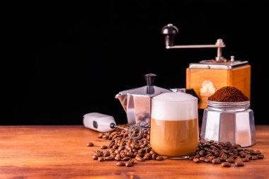 Kafeini tazelemek için taze kafe taze kahve kavrulmuş organik kahve çekirdeği çiftliği antika ahşap öğütücü klasik kahve demliği siyah espresso ve cam kremalı sütlü kapuçino latte için. 