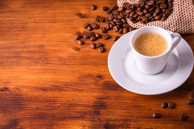 Buharlı beyaz kupa bardakta ev yapımı sıcak espresso organik sürdürülebilir kahve dükkanından mayalanmış kavrulmuş kahverengi fasulye ve yenilenebilir aromalı geri dönüşümlü kağıt paket.