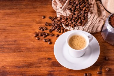 Buharlı beyaz kupa bardakta ev yapımı sıcak espresso organik sürdürülebilir kahve dükkanından mayalanmış kavrulmuş kahverengi fasulye ve yenilenebilir aromalı geri dönüşümlü kağıt paket.