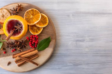 Alman geleneği, yeni yıl Noel pazarı yeni yıl festivali Gluhwein 'i elma portakallı turuncu bardakta sıcak tatlı kırmızı şarap ile baharatlı turunçgil aromalı anason yıldızı anason kadın elini tutuyor.