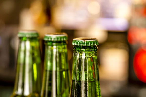 Botellas de cerveza en frente de la barra de luz — Foto de Stock