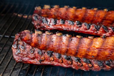 Yandan 2 raf bbq pirzolası ve barbekü sosu ızgara tabağında pişiyor.