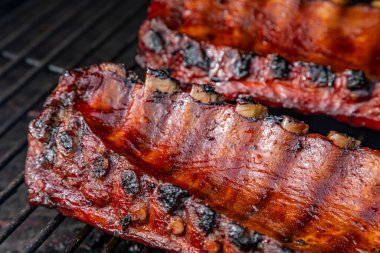Barbekü soslu ve ızgarada pişen 2 sıra bbq pirzolasının yan görüntüsü.