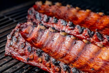 Yandan 2 dilim bbq kaburgası kapatın. Izgarada barbekü sosu pişiyor.