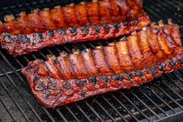 Izgara tabağında pişen barbekü soslu iki raf bbq pirzolası kapat.