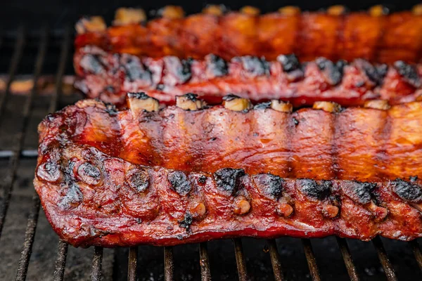 Izgarada barbekü soslu iki raf bbq pirzolasının yan görüntüsü.