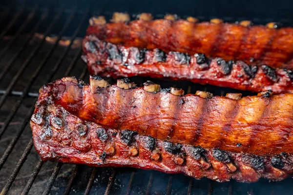 Yandan 2 raf bbq pirzolası ve barbekü sosu ızgara tabağında pişiyor.