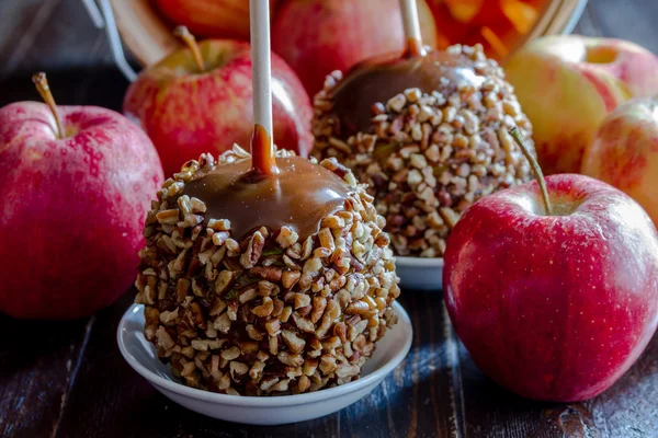 Рука змоченою карамель яблука з горіхами та шоколадом — стокове фото
