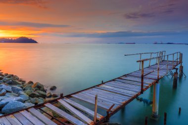 Uzun pozlama gündoğumu deniz terk iskelesi ile. Yumuşak odak, M