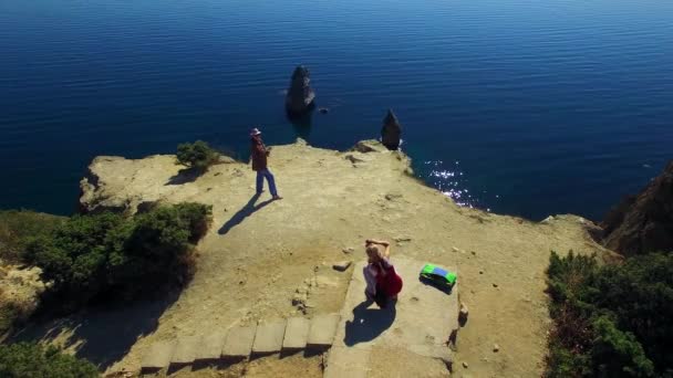 VISTA AERIAL. Dos turistas tomando fotos en Cabo Fiolent Cliff — Vídeo de stock