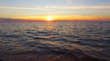 Dalgalar kıyıya günbatımında sıçramasına deniz