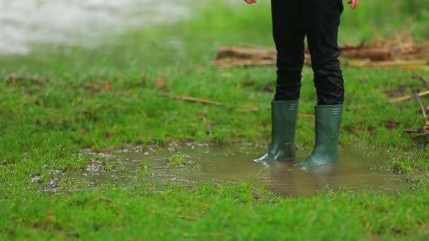 Criança em botas de borracha em pé no pudim — Vídeo de Stock