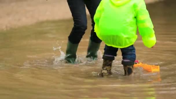 巨大な水たまりに飛び込む幸せな子供たち — ストック動画