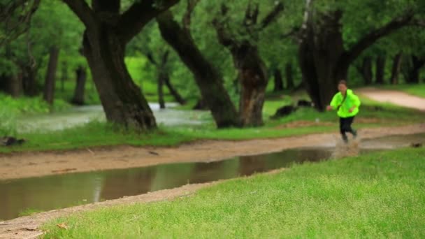 Parkta Büyük Su Birikintisinde Koşan Mutlu Kız — Stok video