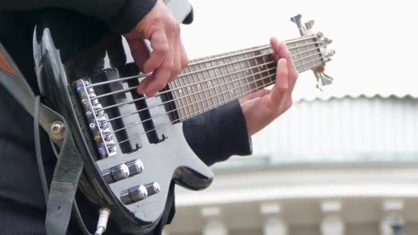 Mãos de homem tocando guitarra baixo elétrico — Vídeo de Stock