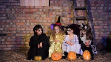 Children in Halloween costumes with pumpkins