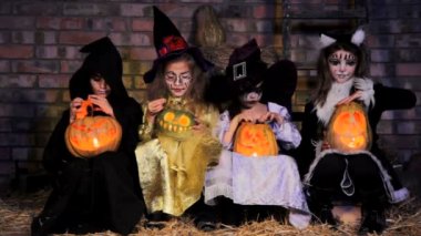Children in Halloween costumes with pumpkins