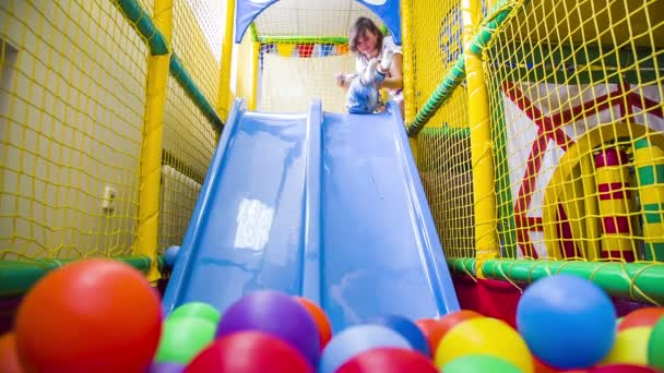 Garçon est glissant dans multicolore balles — Video