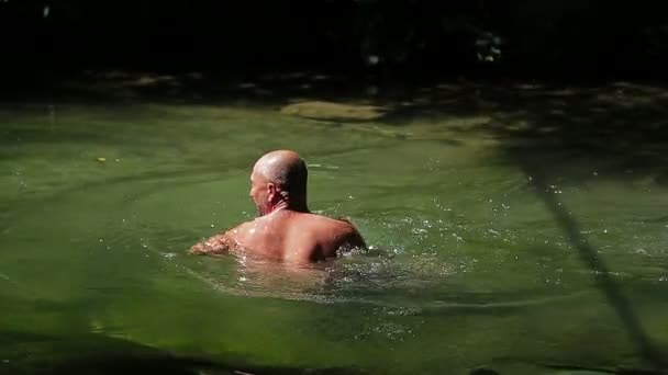 Человек плывет в реке — стоковое видео