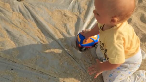 Bebê pequeno com brinquedo rastejando no pano — Vídeo de Stock