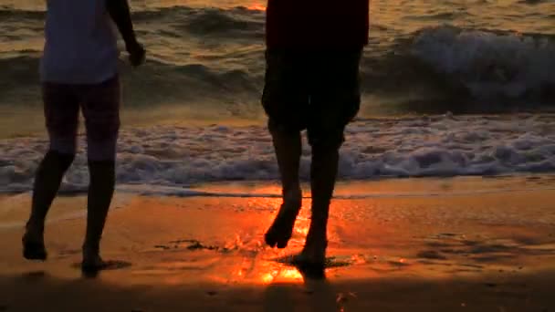 Poika ja tyttö tanssivat rannalla auringonlaskun aikaan — kuvapankkivideo