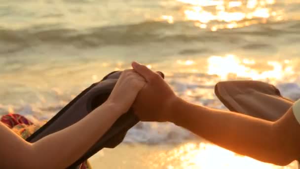 Loving par hålla händer när du sitter på utomhus stolar på stranden — Stockvideo