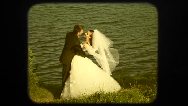 Feliz recién casados cerca del lago en el día de la boda — Vídeo de stock